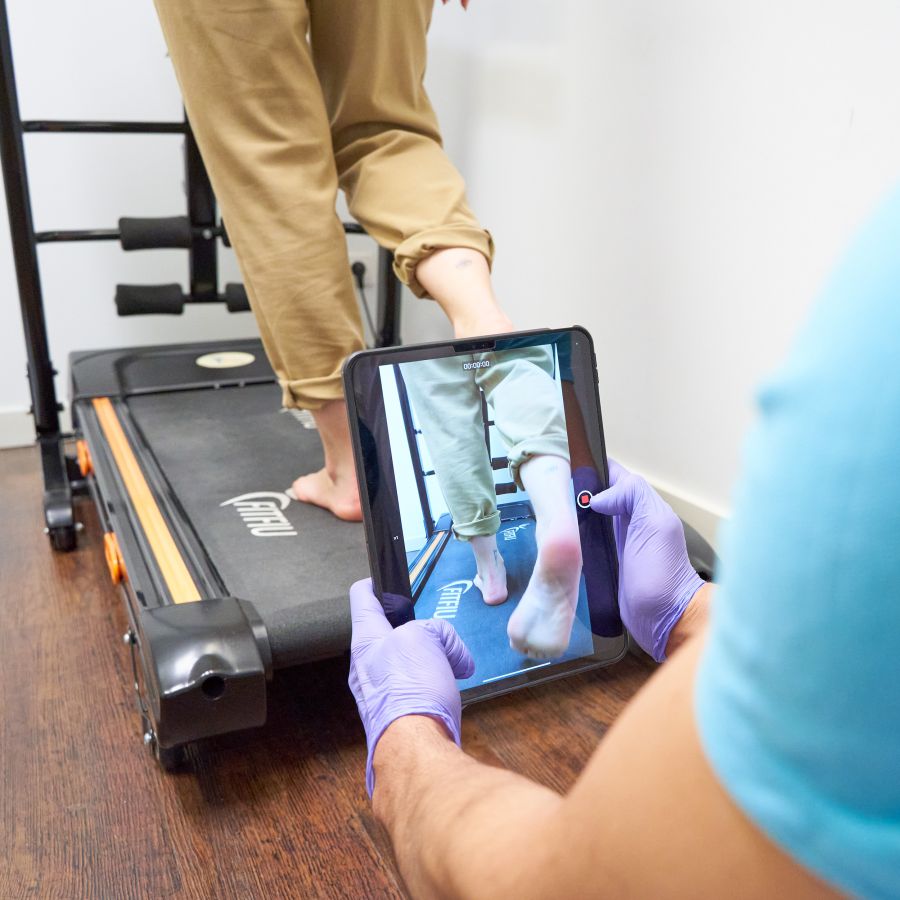 Imagen de profesional grabando con tableta a los pies de una clienta 