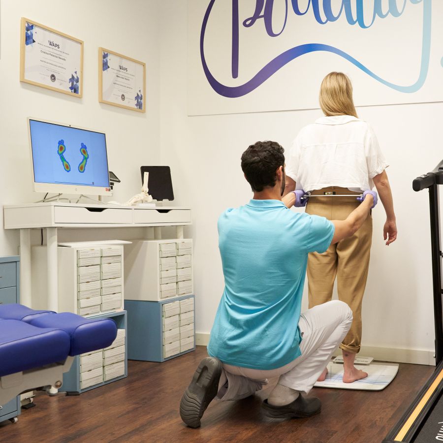 Imagen del servicio Podología deportiva con profesional midiendo altura de cadera a los pies 